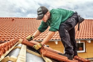 Roofer at work, installing clay roof tiles, Germany